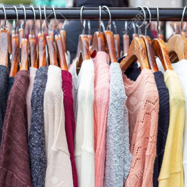 159730004 warme multi kleuren truien op hangers in een winkel close up