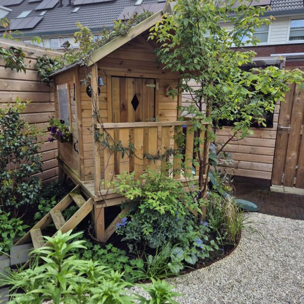 Speelhuisje in de groene tuin van Jan