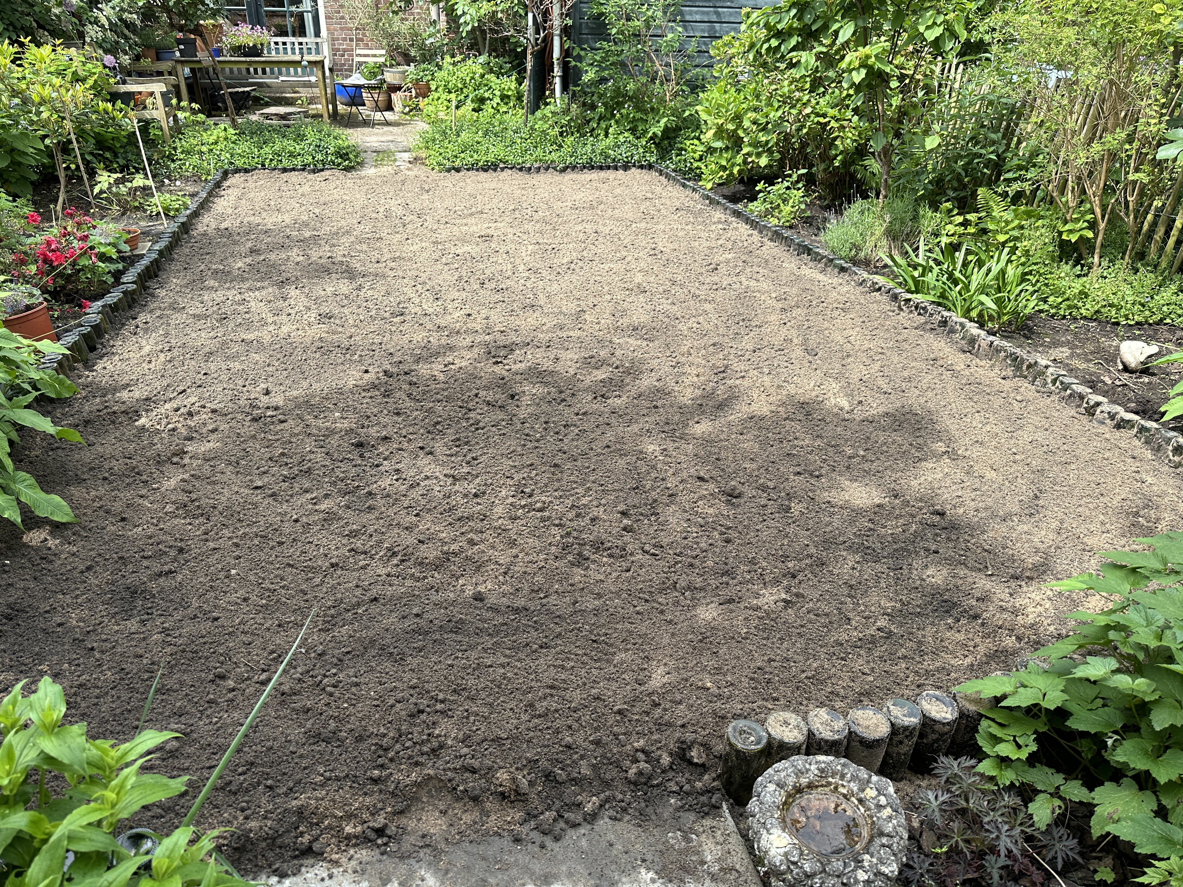 Zand en aarde over het geotextiel